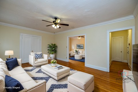 A living room with a white couch and a blue rug.