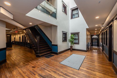 a large living room with a staircase and wood floors