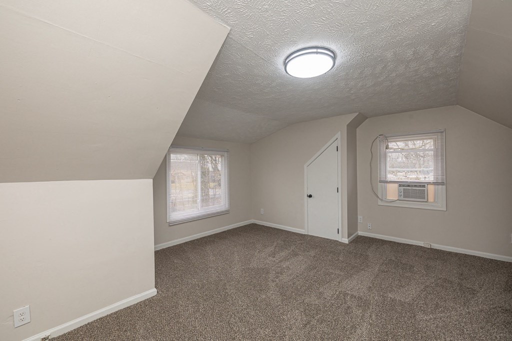 Upstairs bedroom with new carpeting, angled closet, and windows