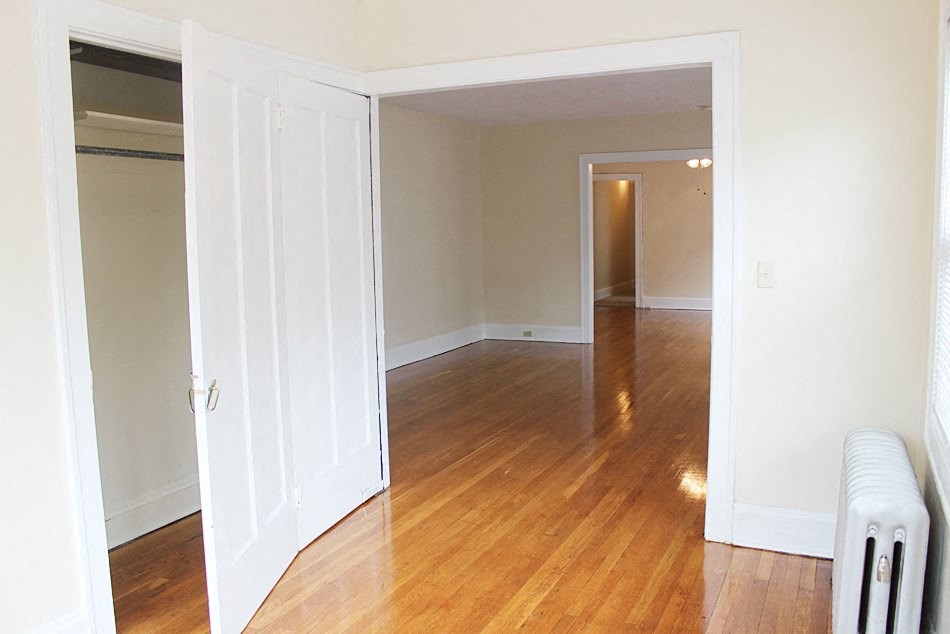 an empty living room with a wood floor and a closet