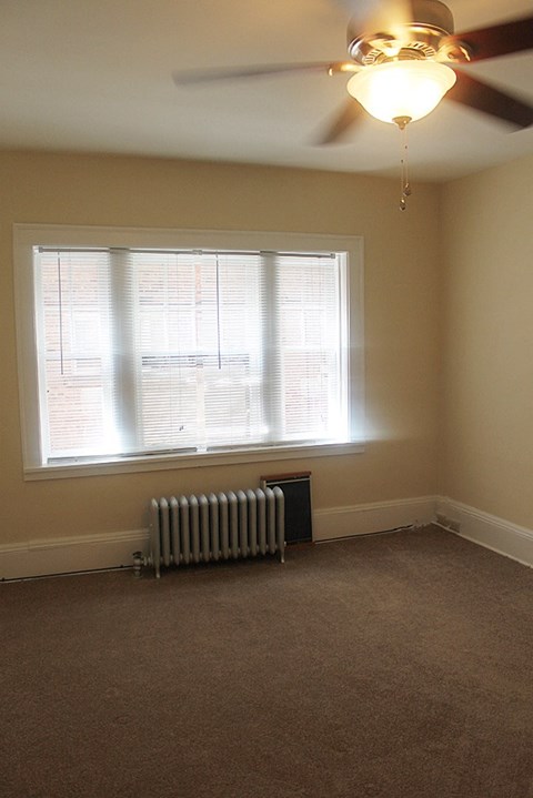 an empty room with a radiator and a window