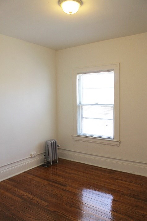 an empty room with a suitcase on the floor and a window