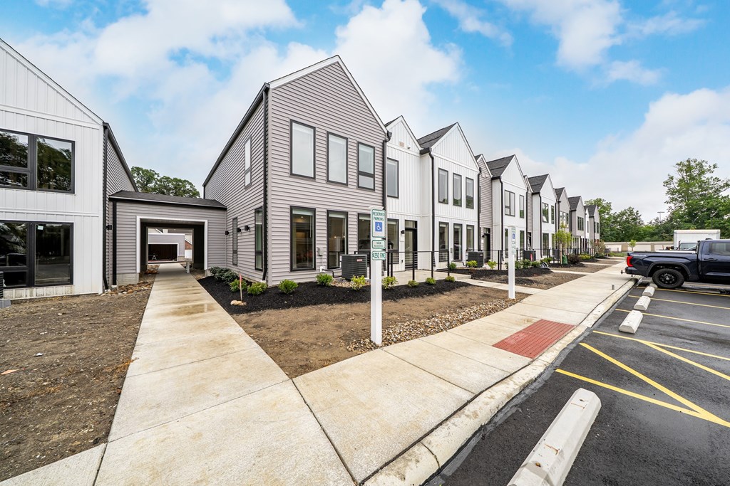 A row of modern houses with a truck parked in the driveway.