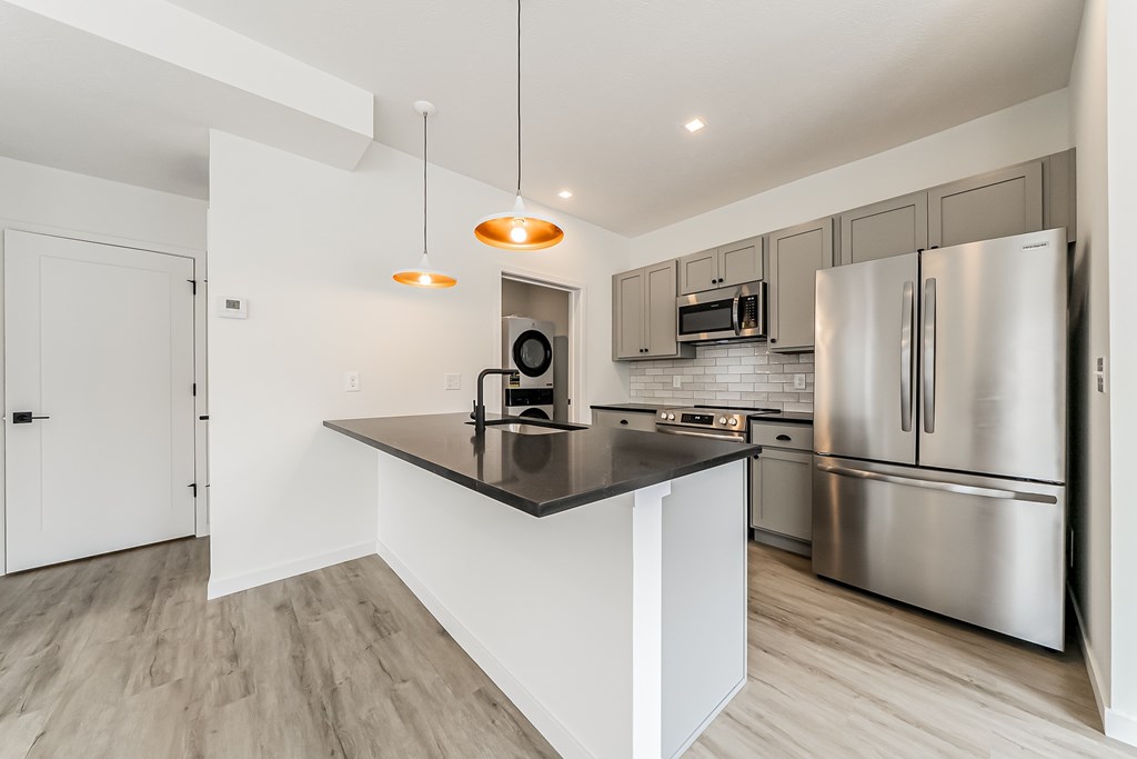 A modern kitchen with stainless steel appliances and a central island.