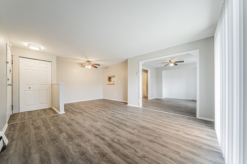 A spacious room with a ceiling fan and lighting fixtures.