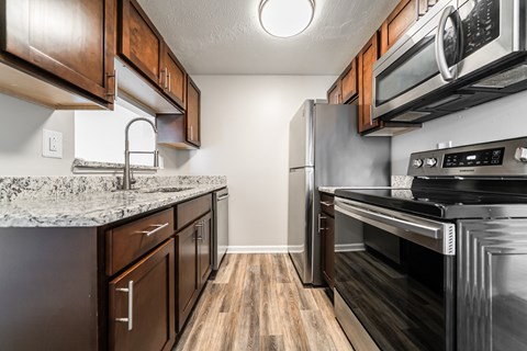 A kitchen with dark wood cabinets and stainless steel appliances.