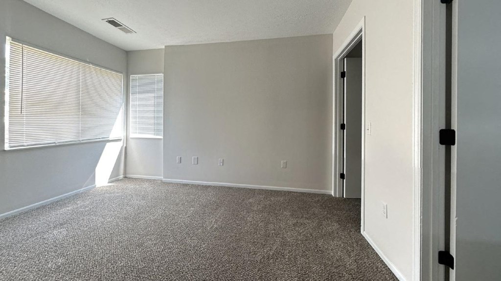 an empty room with a window and a door