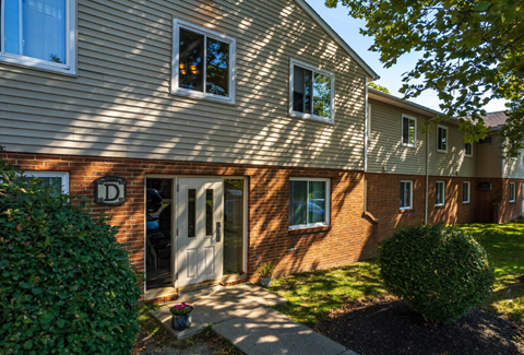 a side view of a brick house with a white door