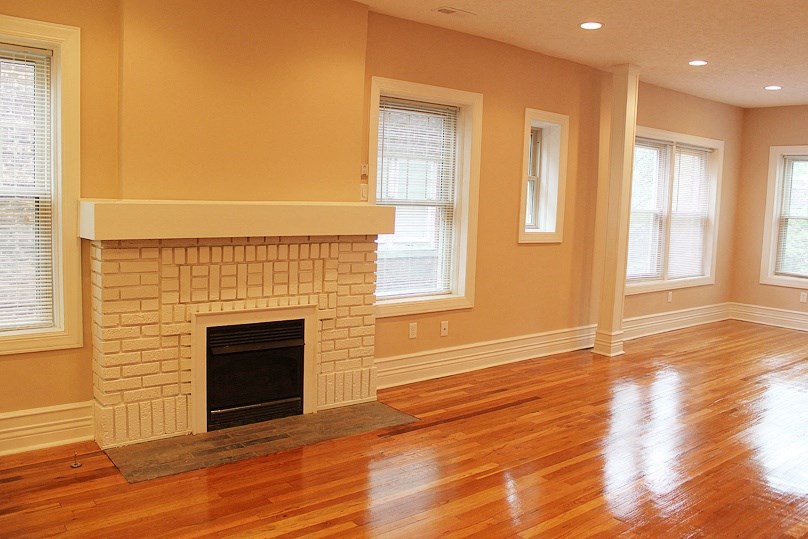 a living room with a fireplace and a wooden floor