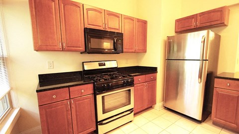 A kitchen with wooden cabinets and a black stove top.