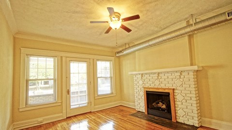A room with a fireplace and a ceiling fan.