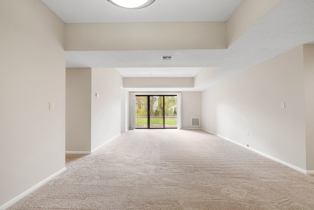 A spacious living room with sliding glass doors to a balcony.at Atrium in The Village, Beachwood Ohio