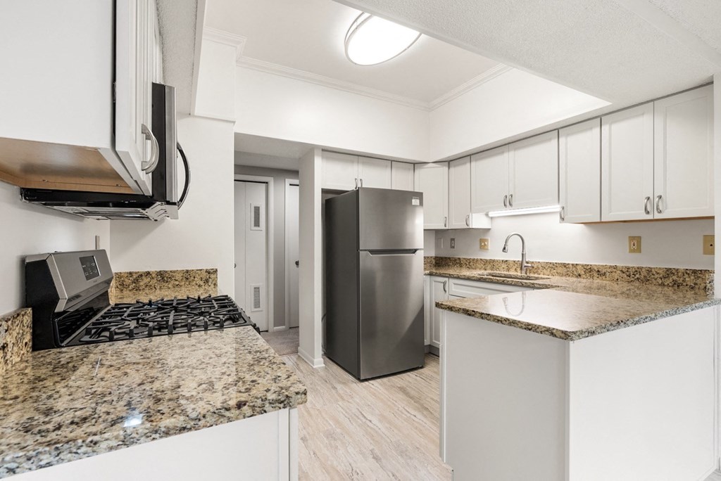 A kitchen with granite countertops and stainless steel appliances.at Atrium in The Village, Beachwood, OH 44122