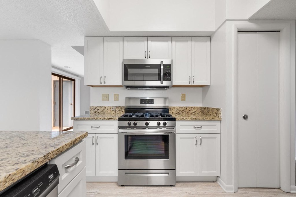 A kitchen with a granite countertop and stainless steel appliances.at Atrium in The Village, Ohio, 44122