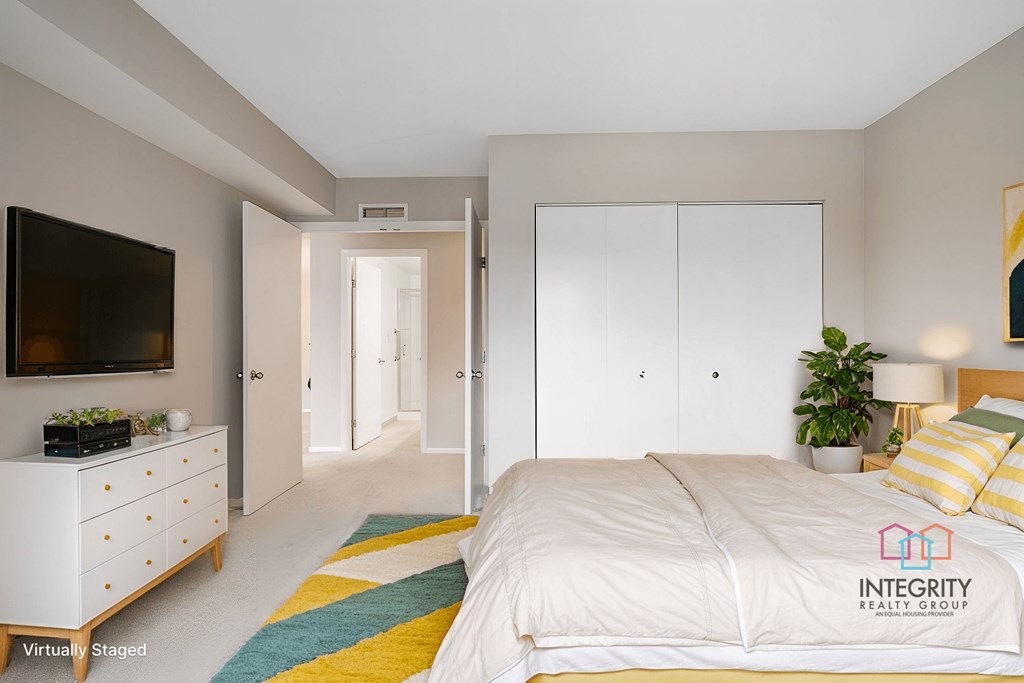 A furnished guest bedroom with a large closet.at Atrium in The Village, Ohio