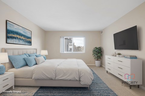Virtually staged bedroom with upholstered bed and dresser at Atrium in The Village Apartments, Beachwood
