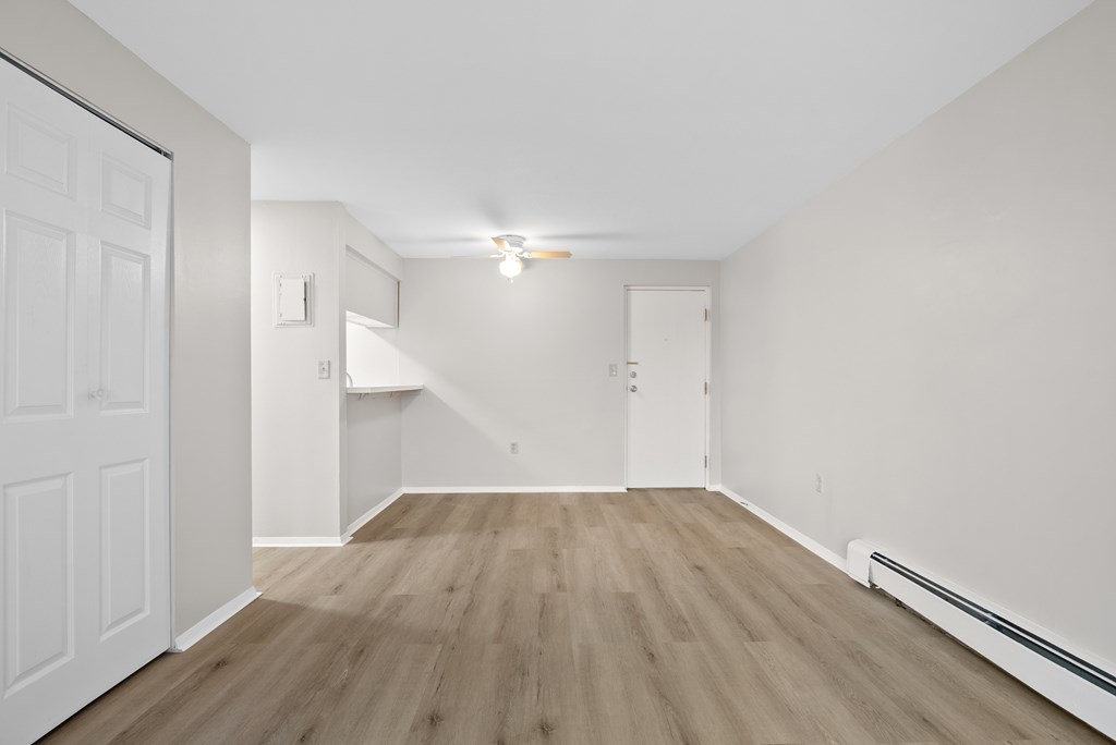 A room with wooden flooring and white walls.