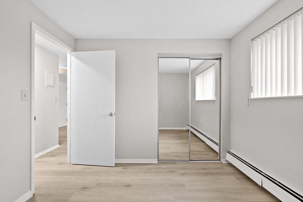Bedroom with mirrored closet doors.