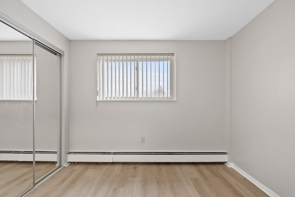 A bedroom with a mirrored closet.
