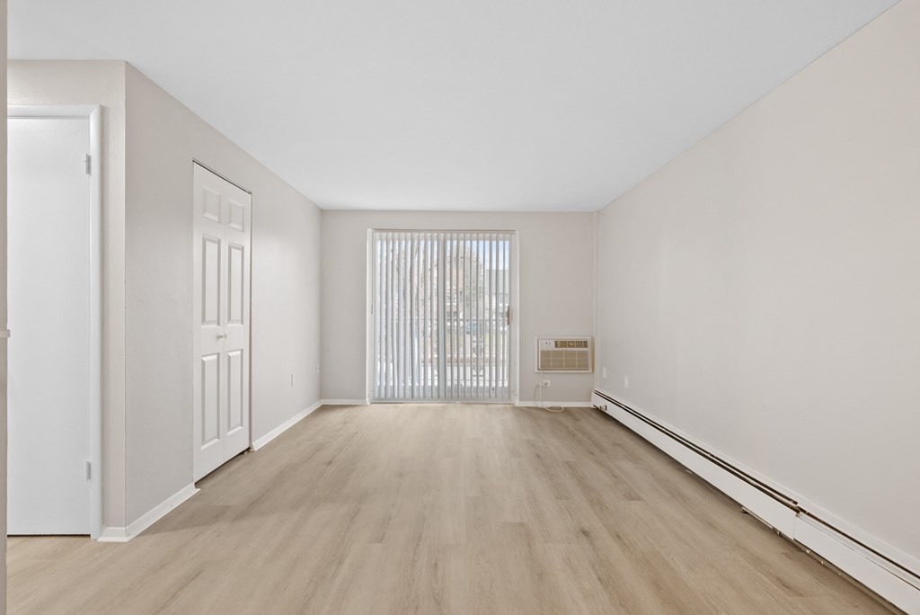 Large living room with ash wood flooring, a closet, and a sliding door to a balcony.