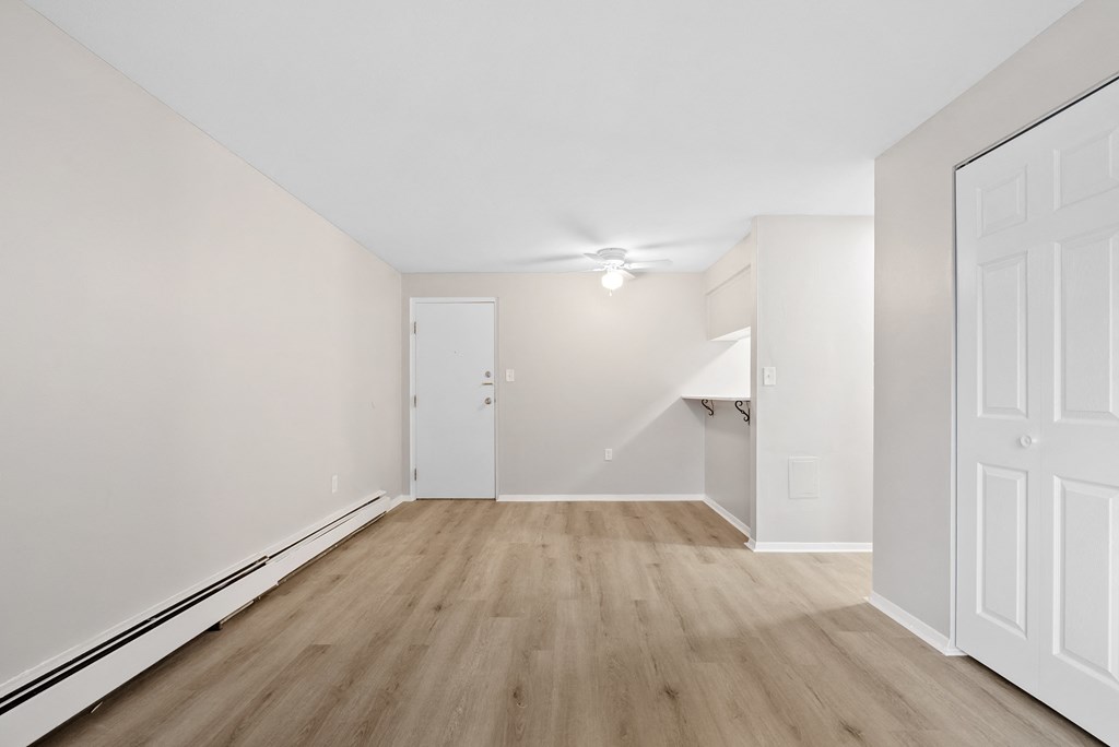 Entryway to living room with a white closet and a white ceiling fan.