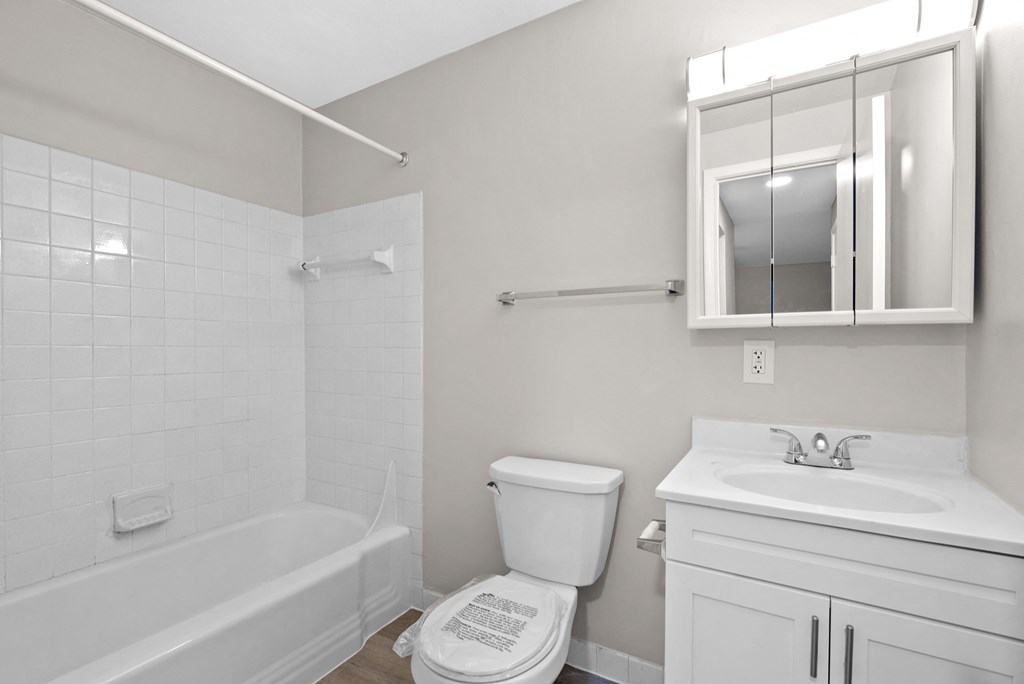 A white bathroom with a toilet, sink, and bathtub.