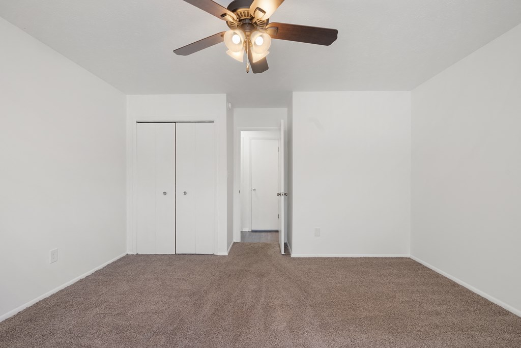 Updated Wynwood bedroom, carpeted, with closet and ceiling fan.