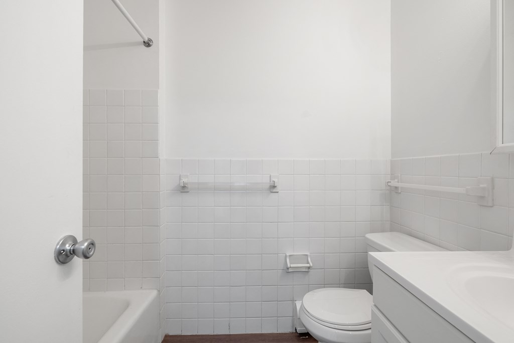 Updated Wynwood bathroom featuring all white counters and new bathtub.