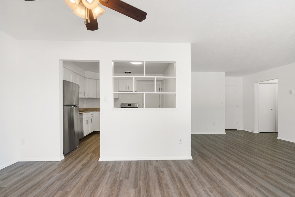 Updated Wynwood dining area and living room with plank-style flooring and a ceiling fan.