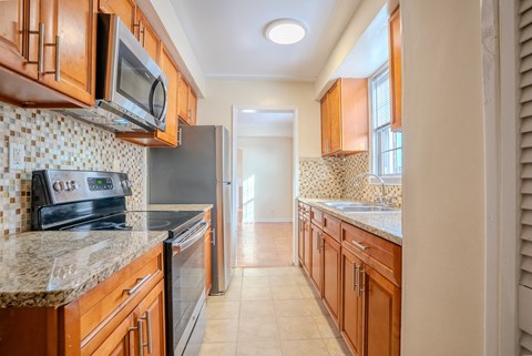 A kitchen with wooden cabinets and a tile backsplash.