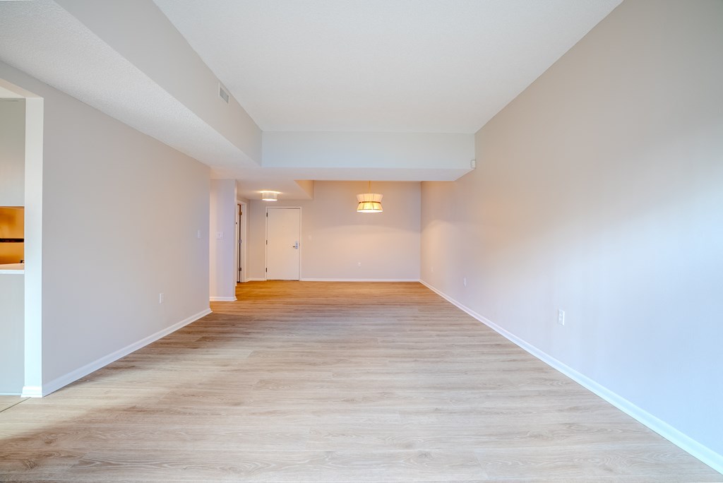 A long, empty hallway with light wood flooring and white walls t Atrium in The Village, Beachwood, OH 44122