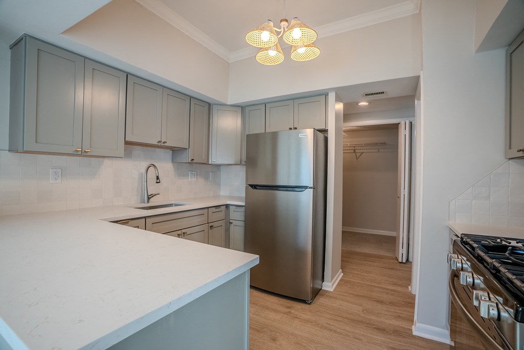 A kitchen with a refrigerator, stove, and cabinets t Atrium in The Village, Beachwood