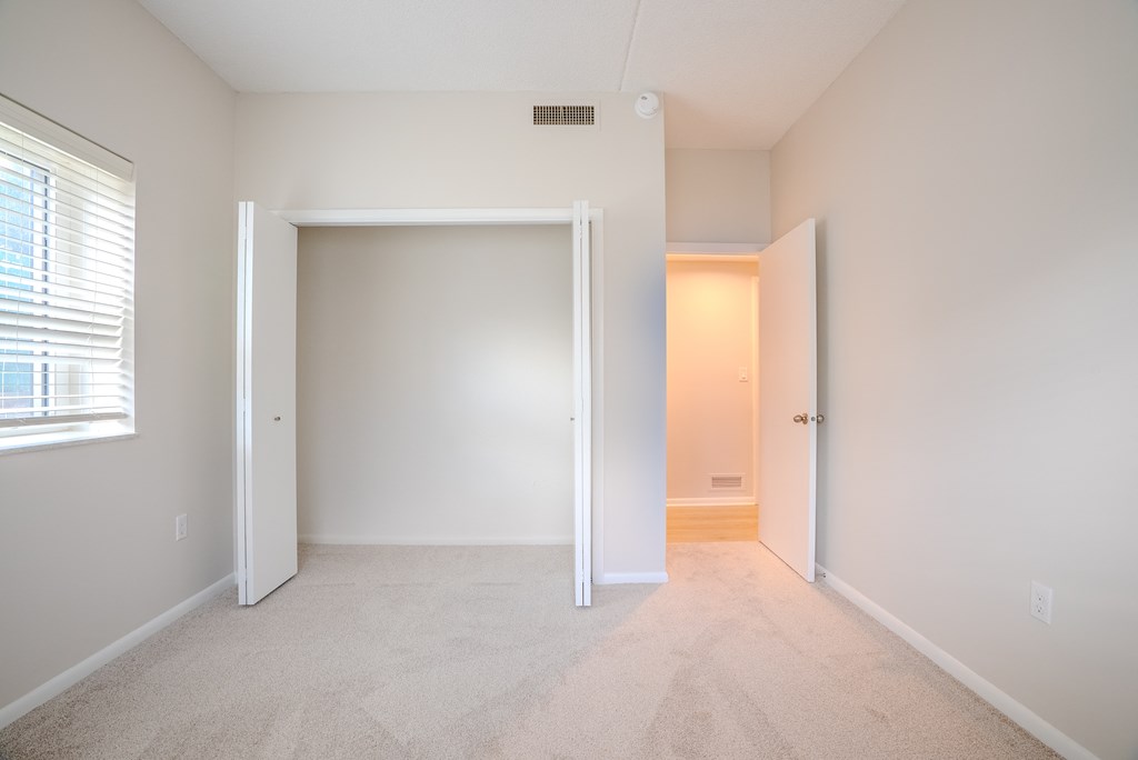 A white room with a carpeted floor and a window with blinds t Atrium in The Village, Beachwood, OH 