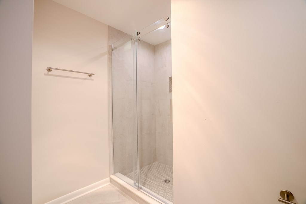 A white bathroom with a glass shower door t Atrium in The Village, Beachwood, OH 44122