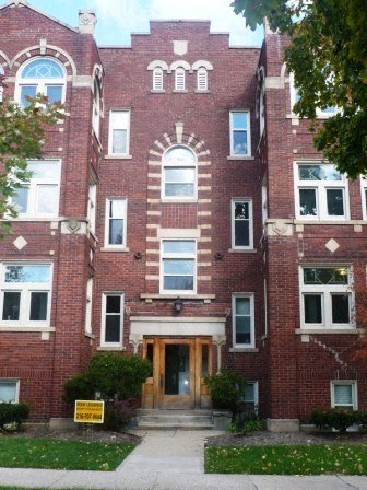 the front of a brick building with a wooden door