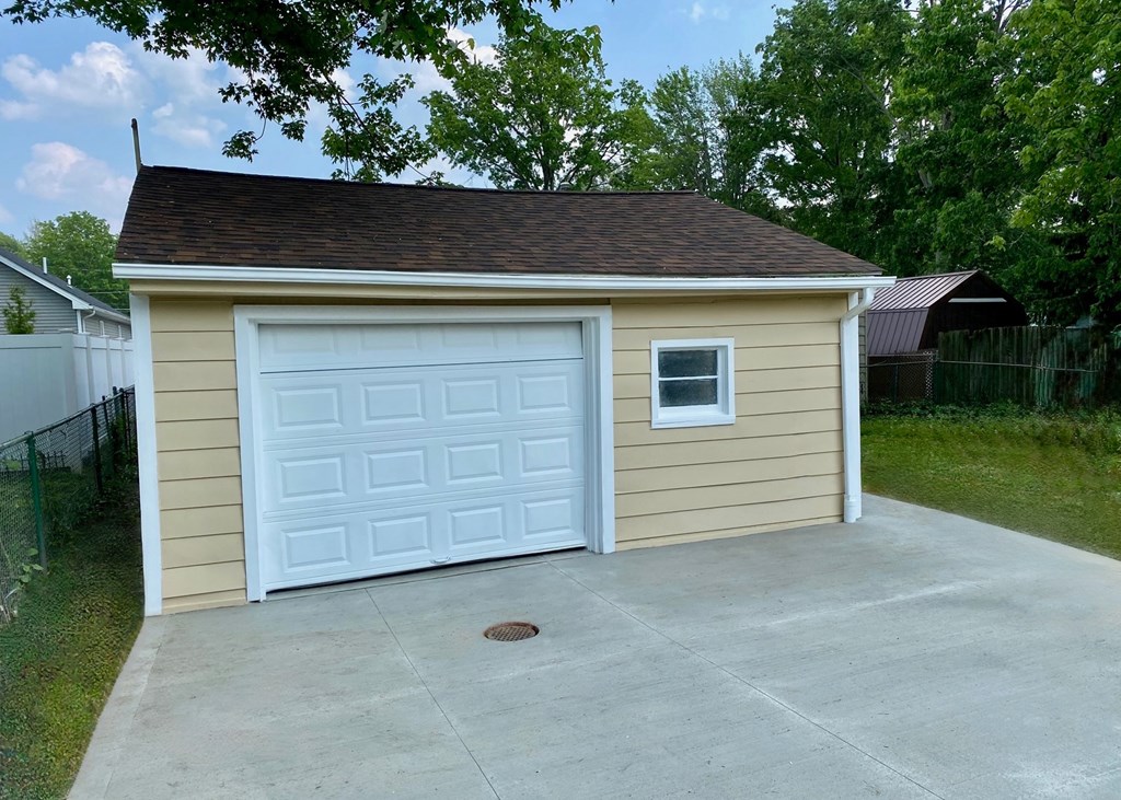 A small garage with a white door and a small window on the side.