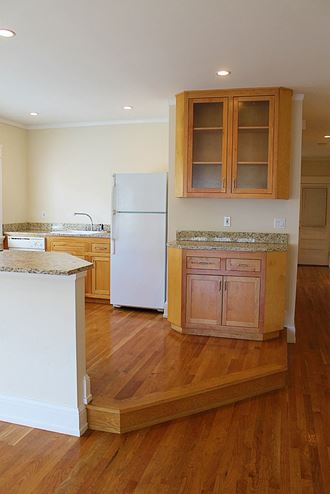 a kitchen with wooden floors and a refrigerator