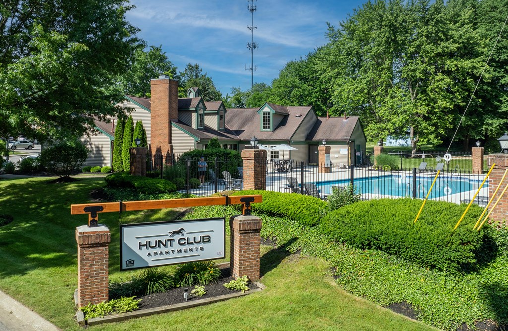 a home with a sign for hunt club in front of a swimming pool a home with a sign for hunt club in front of a swimming pool at Hunt Club Apartments, Integrity Realty, 44321