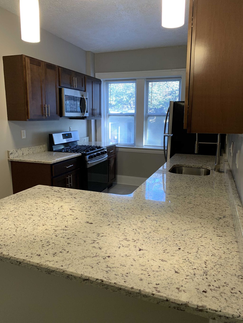 an empty kitchen with a granite counter top