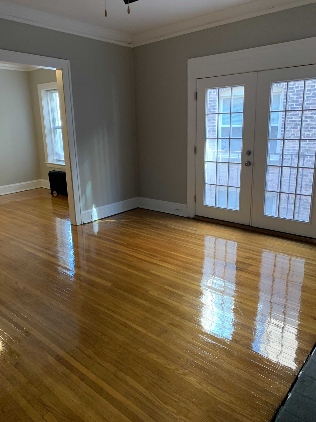a living room with a hard wood floor and two doors