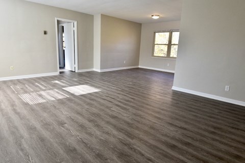 an empty living room with a hard wood floor