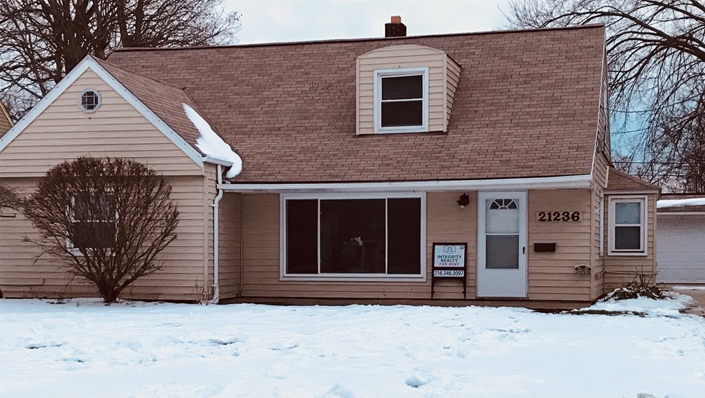 a house in the snow with a sign in the window