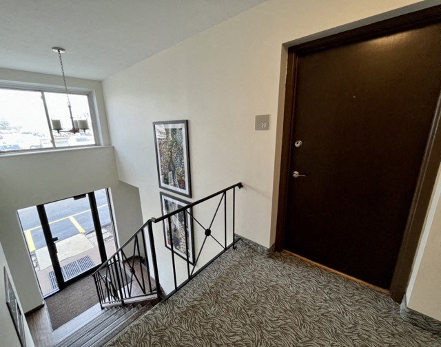 a view from the top of the stairs looking down at the door