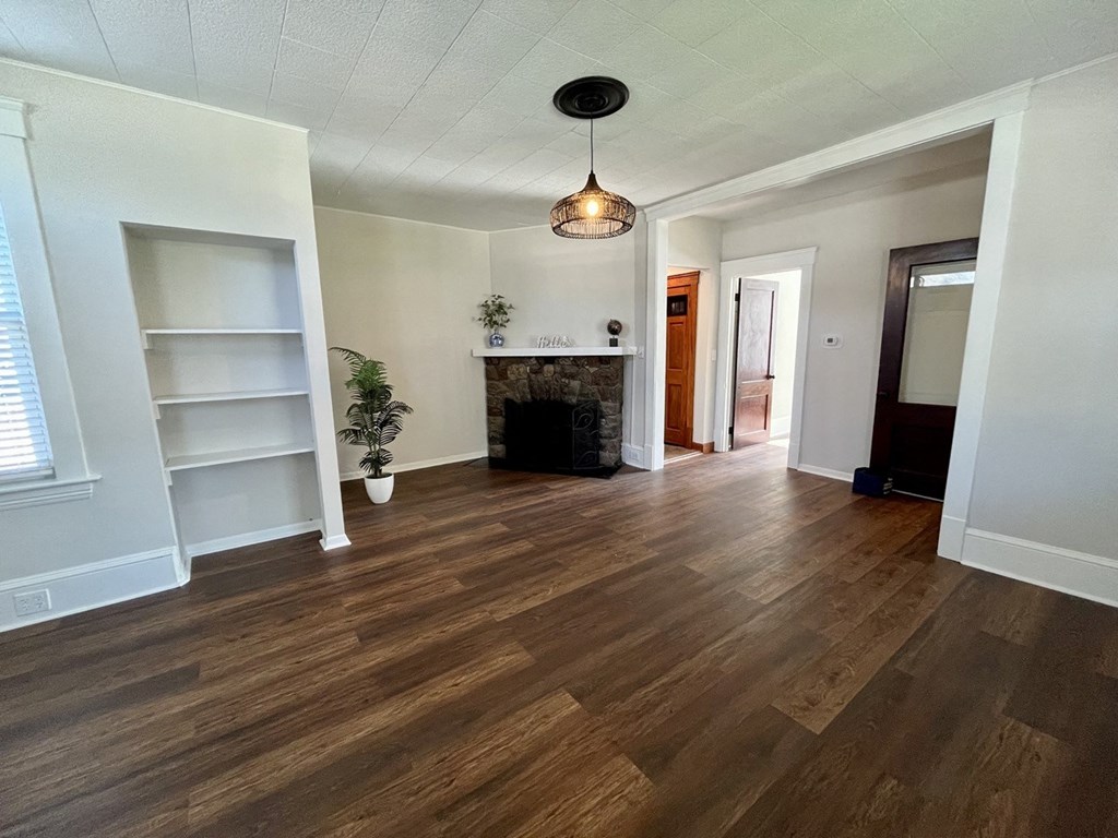 a living room with hardwood floors and a fireplace