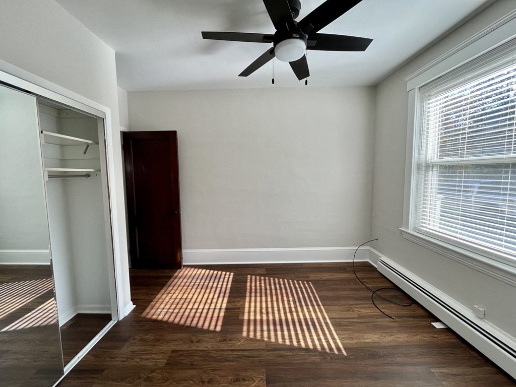 an empty room with a ceiling fan and a closet