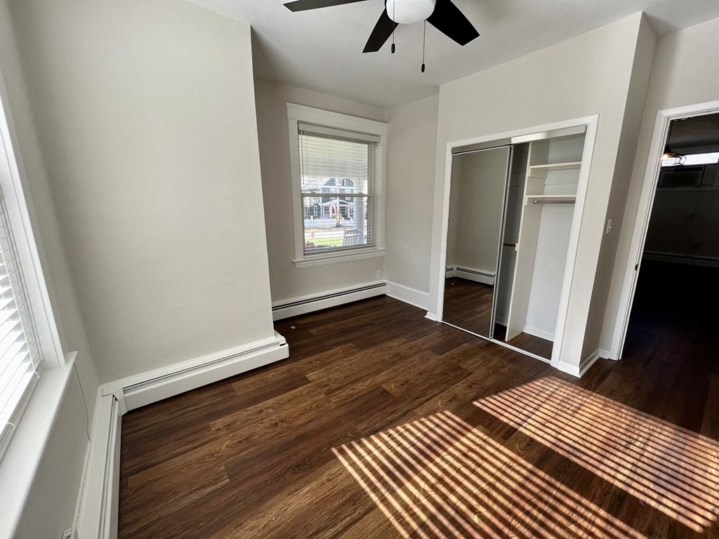 a living room with wood floors and a ceiling fan