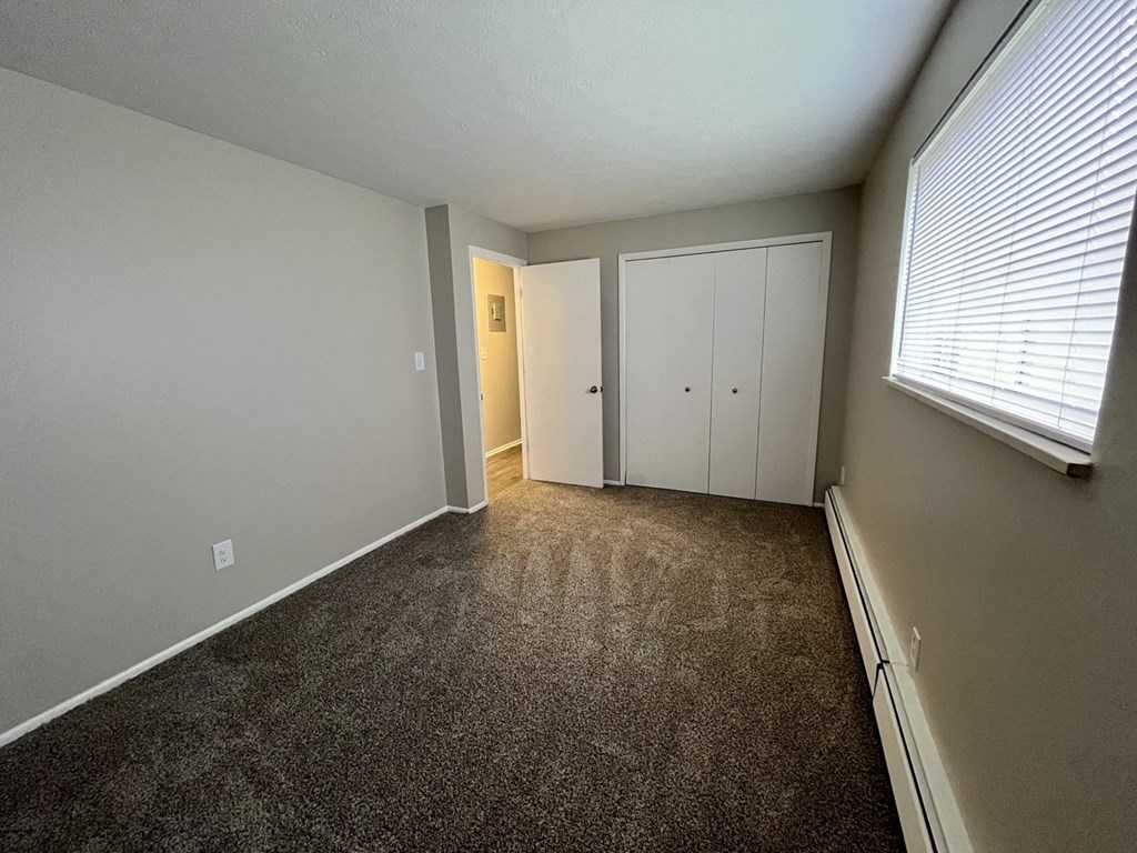 an empty room with carpet and a large window