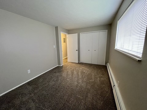 an empty room with carpet and a large window
