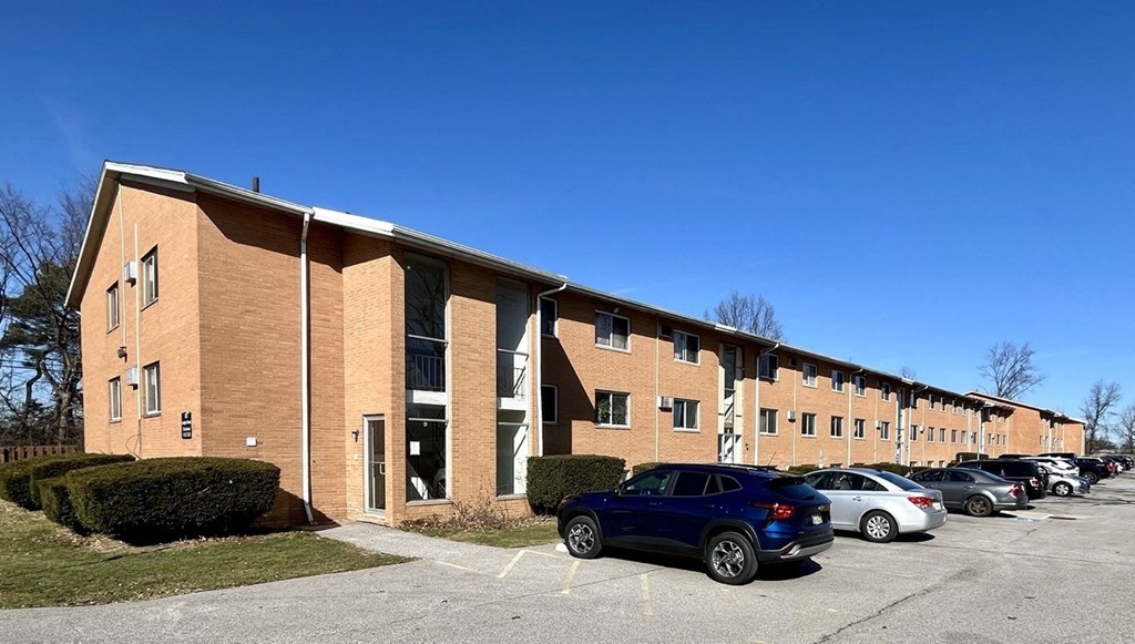 a large brick building with cars parked in a parking lot