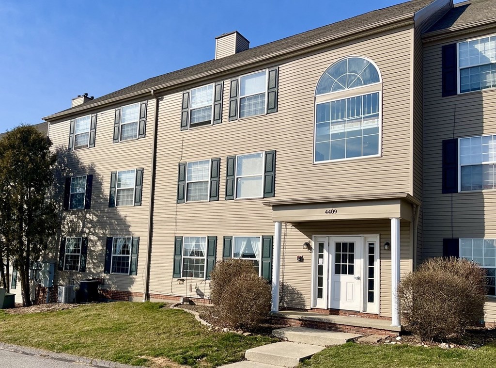 a large house with a white door and a lawn